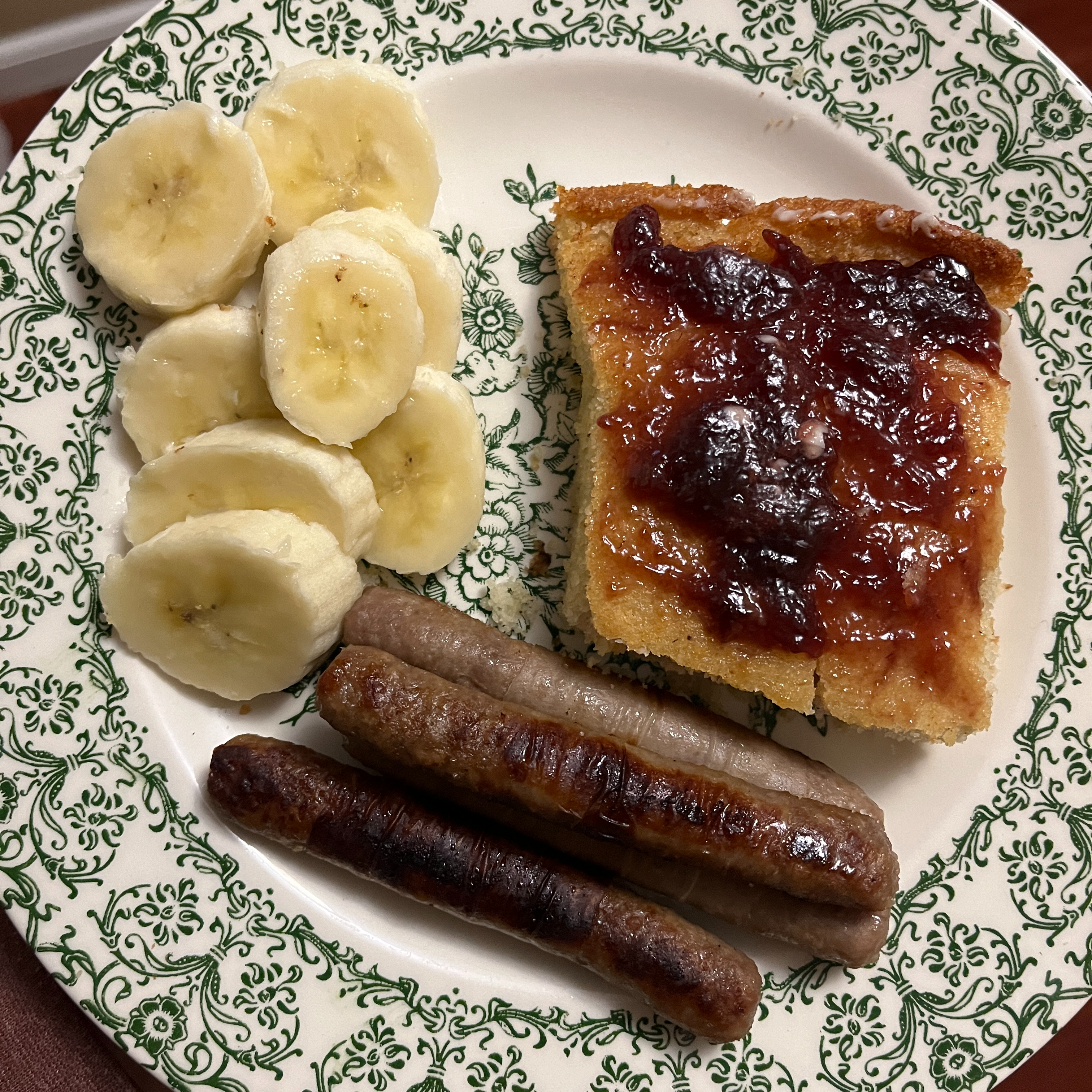 Banana slices, sausage links, and cornbread with jam