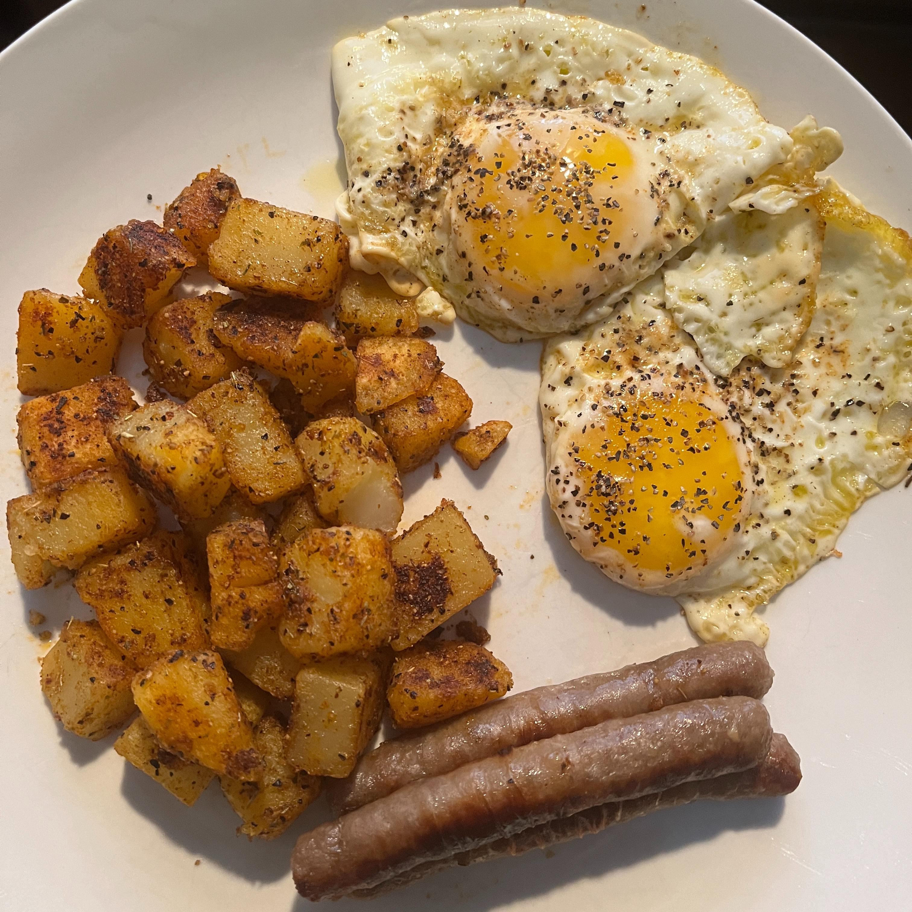 Fried potatoes, eggs sunny side up, sausage links